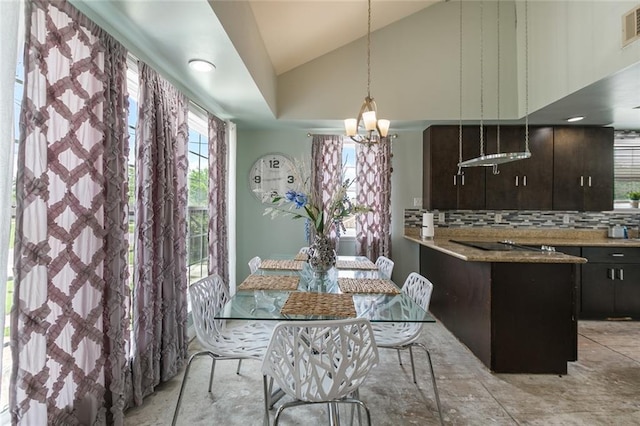 dining area featuring a chandelier, vaulted ceiling, and visible vents