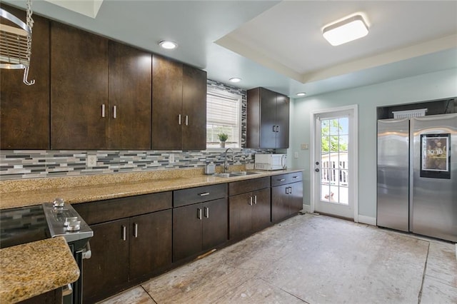 kitchen featuring decorative backsplash, smart refrigerator, dark brown cabinets, a sink, and electric stove