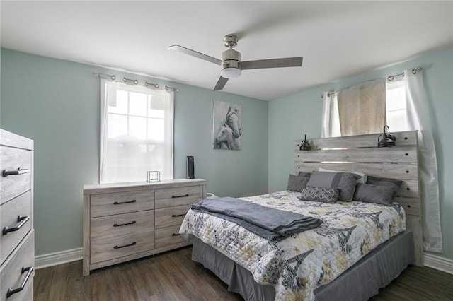 bedroom with baseboards, multiple windows, and dark wood-type flooring
