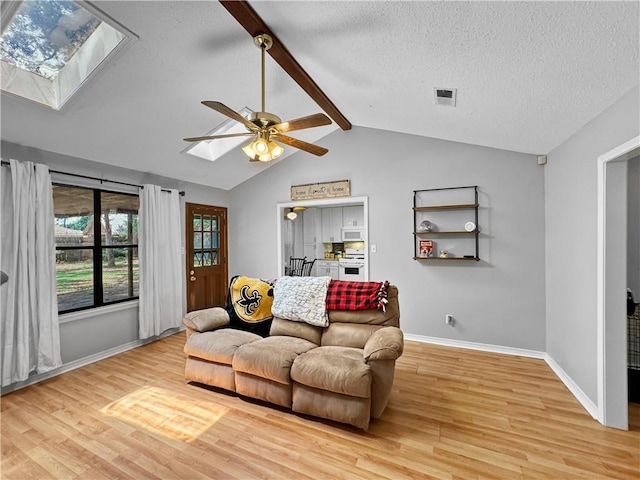 115 Spruce Cir, Slidell, LA 70458 - living room with a skylight, wood finished floors, a ceiling fan, and a textured ceiling