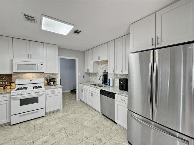 115 Spruce Cir, Slidell, LA 70458 - kitchen with appliances with stainless steel finishes, tasteful backsplash, and white cabinets