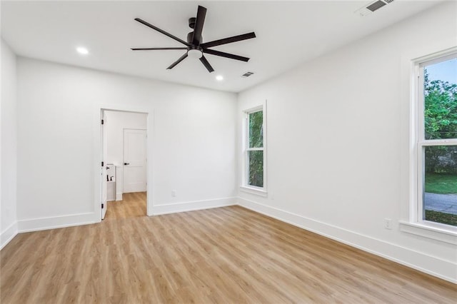 empty room featuring baseboards, visible vents, and light wood-type flooring