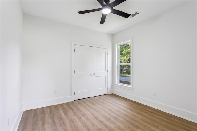 unfurnished bedroom with baseboards, visible vents, light wood-style flooring, and a closet