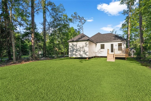 rear view of property with a yard and a deck