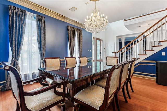 dining area with baseboards, an inviting chandelier, wood finished floors, and stairway