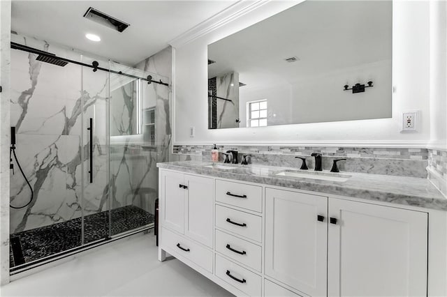 full bath with visible vents, a sink, a marble finish shower, and double vanity