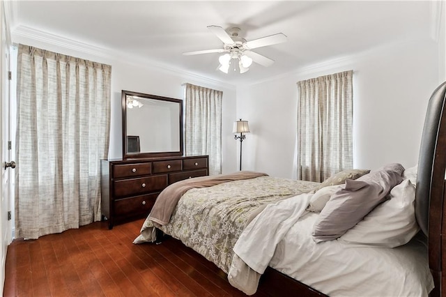 bedroom featuring a ceiling fan, ornamental molding, and dark wood-type flooring