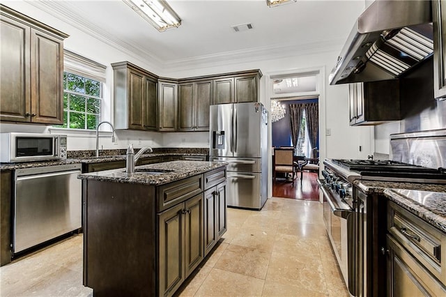 kitchen featuring exhaust hood, visible vents, appliances with stainless steel finishes, a sink, and dark stone countertops