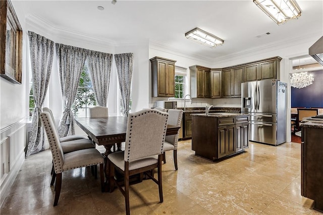 4232 Fontainebleau Dr, New Orleans, LA 70125 - kitchen featuring stainless steel fridge with ice dispenser, a kitchen island with sink, a chandelier, crown molding, and dark brown cabinetry