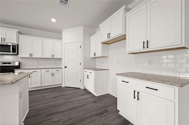 kitchen featuring tasteful backsplash, stainless steel appliances, and visible vents