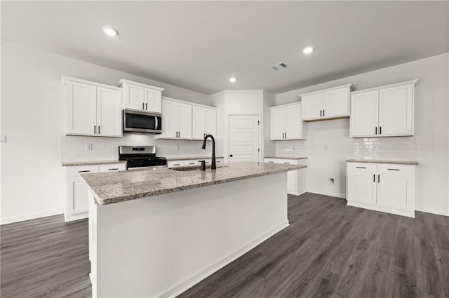 kitchen featuring appliances with stainless steel finishes, a sink, white cabinetry, decorative backsplash, and visible vents