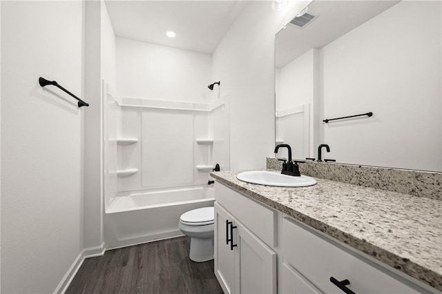 full bath featuring vanity, wood finished floors, toilet, baseboards, and shower / bath combination