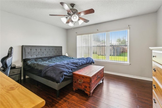 bedroom with baseboards, a ceiling fan, dark wood-style floors, and a textured ceiling