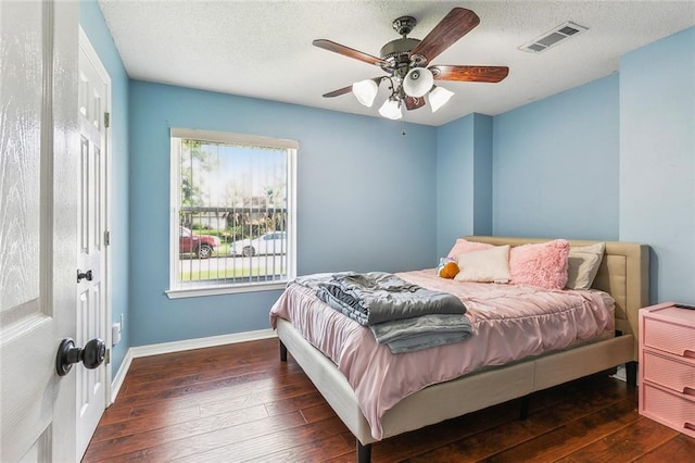 bedroom with baseboards, visible vents, ceiling fan, and hardwood / wood-style floors