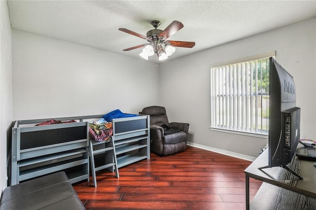 home office with baseboards, ceiling fan, a textured ceiling, and wood finished floors