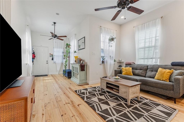 living room featuring recessed lighting, a ceiling fan, light wood finished floors, and baseboards