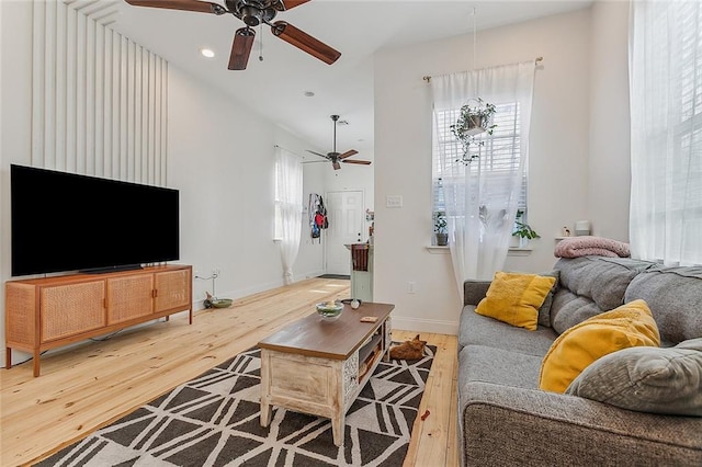 living area featuring baseboards, recessed lighting, ceiling fan, and light wood-style flooring