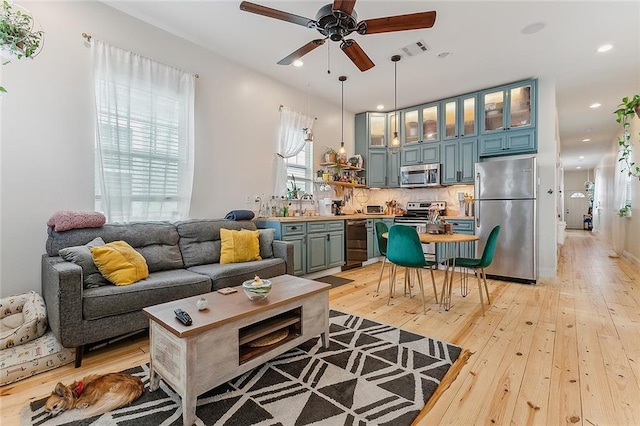 living area featuring a ceiling fan, visible vents, recessed lighting, and light wood-type flooring