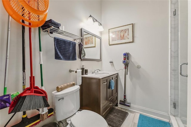 bathroom featuring baseboards, vanity, toilet, and a shower stall