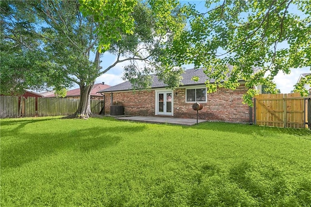 back of property featuring a lawn, brick siding, a patio, and a fenced backyard