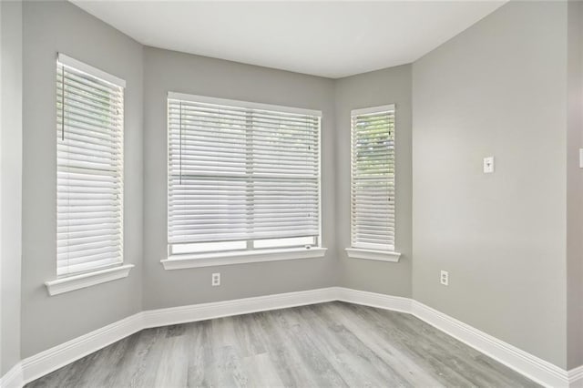 unfurnished room with baseboards and wood finished floors