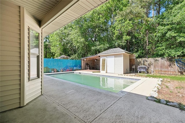 view of pool with an outbuilding, a patio area, a fenced in pool, a fenced backyard, and a storage unit