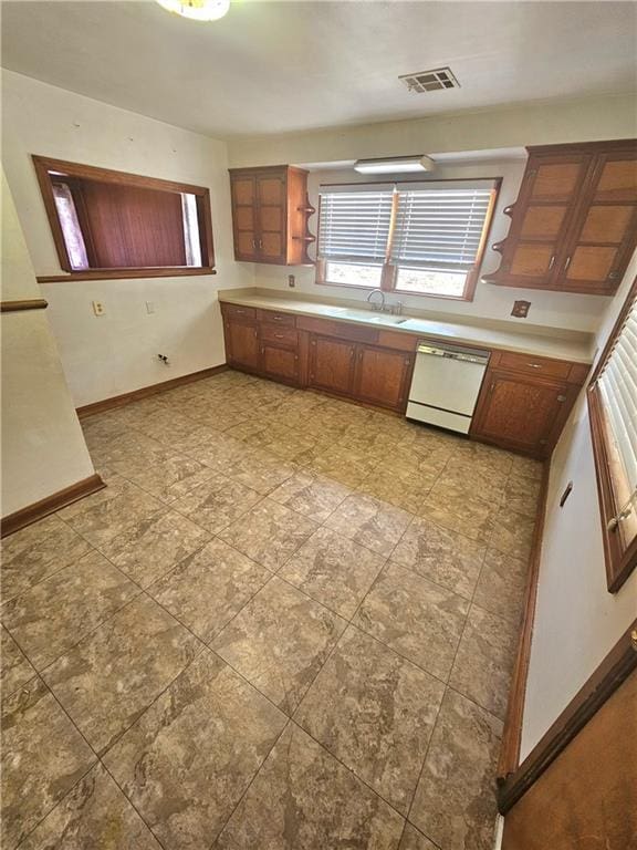 813 2nd Ave, Harvey, LA 70058 - kitchen with white dishwasher, a sink, light countertops, baseboards, and visible vents
