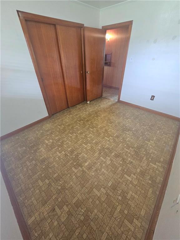 813 2nd Ave, Harvey, LA 70058 - unfurnished bedroom featuring a closet, baseboards, and crown molding