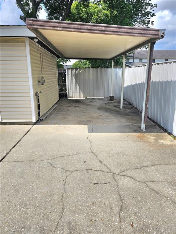 813 2nd Ave, Harvey, LA 70058 - view of vehicle parking with fence, an attached carport, and aphalt driveway