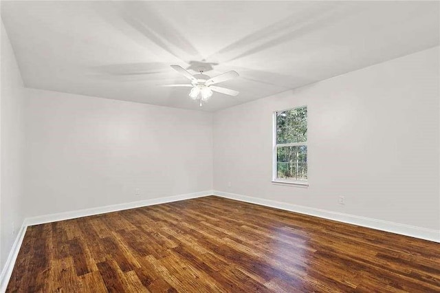 empty room featuring a ceiling fan, baseboards, and wood finished floors