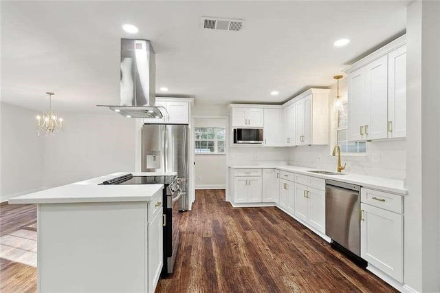 kitchen with visible vents, island range hood, a sink, stainless steel appliances, and white cabinetry