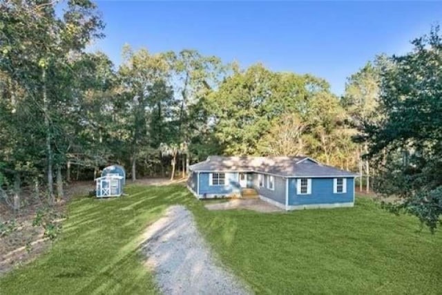 exterior space with a yard and dirt driveway