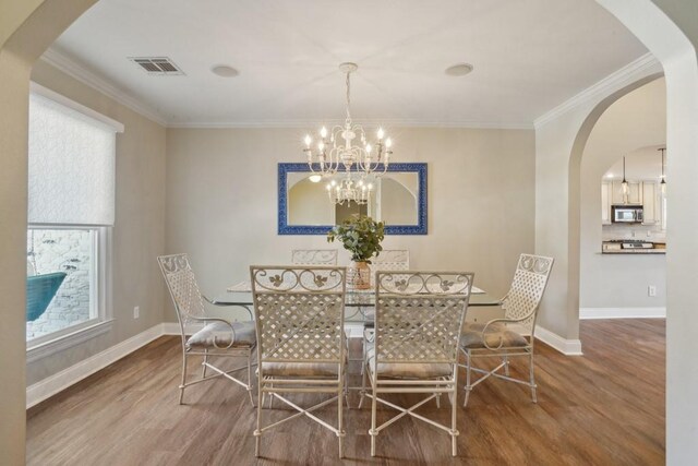 3909 Courtland St, Metairie, LA 70002 - dining area featuring visible vents, wood finished floors, baseboards, an inviting chandelier, and ornamental molding