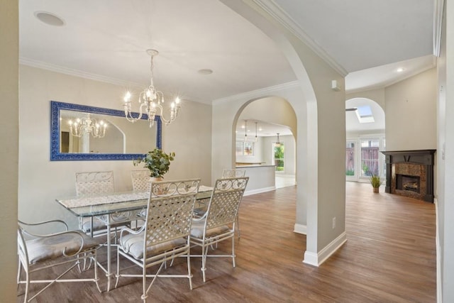 3909 Courtland St, Metairie, LA 70002 - dining area featuring crown molding, an inviting chandelier, wood finished floors, a fireplace, and baseboards