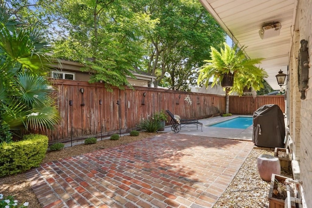 view of patio featuring a fenced in pool, a fenced backyard, and a grill