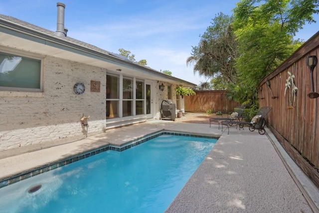 view of pool featuring a fenced in pool, a fenced backyard, and a patio area