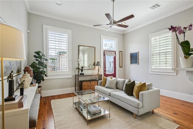 living area featuring visible vents, wood finished floors, and a healthy amount of sunlight