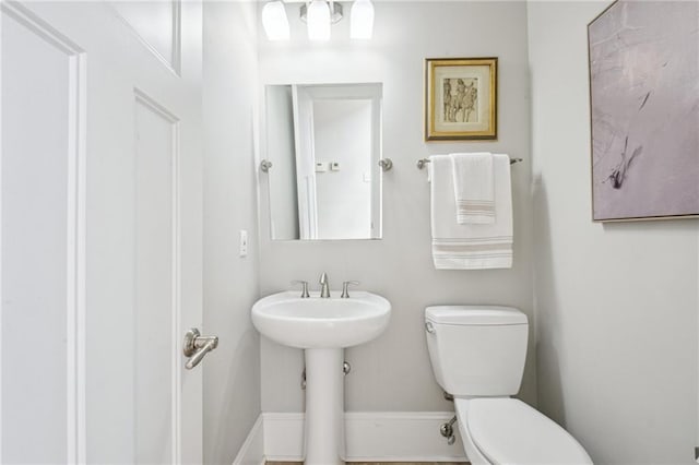 half bathroom featuring a sink and toilet