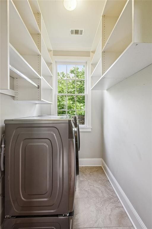 laundry room featuring baseboards, washing machine and clothes dryer, laundry area, and visible vents