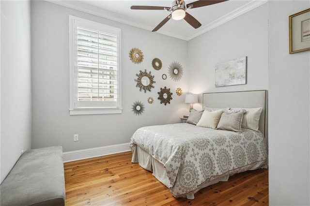 bedroom featuring crown molding, a ceiling fan, baseboards, and wood finished floors