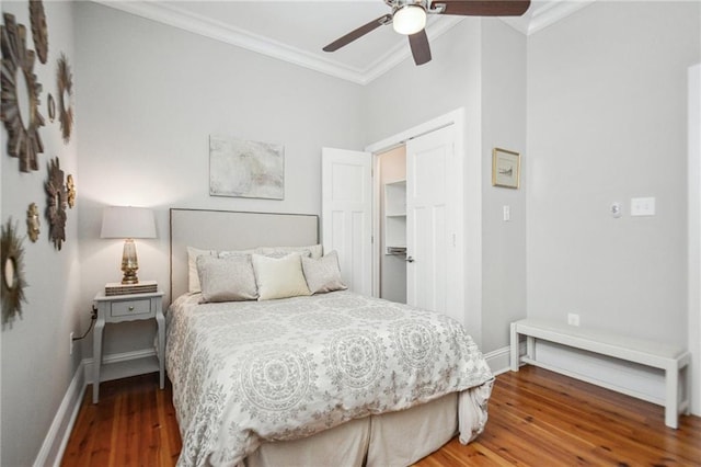 bedroom with crown molding, baseboards, ceiling fan, and wood finished floors