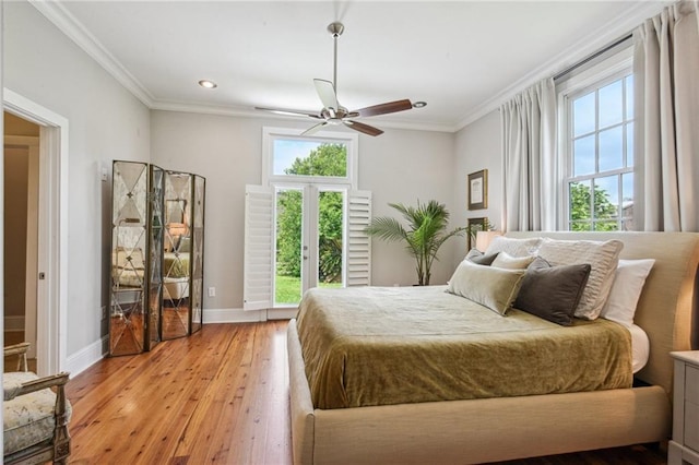 bedroom with baseboards, multiple windows, and light wood-type flooring