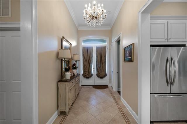 doorway to outside with an inviting chandelier, crown molding, visible vents, baseboards, and light tile patterned floors