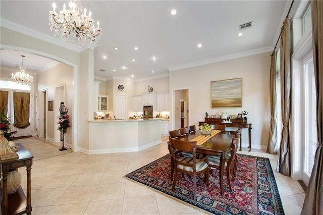 dining room featuring crown molding, an inviting chandelier, arched walkways, light tile patterned floors, and visible vents