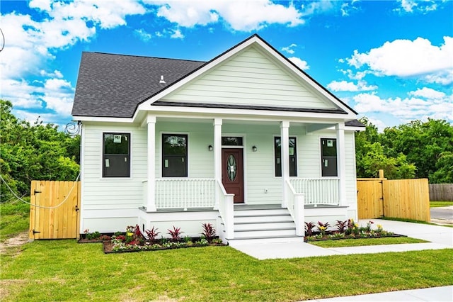 bungalow featuring a porch, a front yard, a gate, fence, and a shingled roof