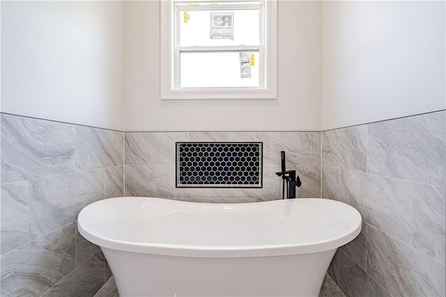 full bathroom featuring tile walls and a soaking tub