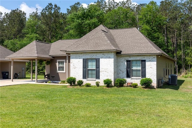 18203 Fox Hollow Loop, Hammond, LA 70401 - view of front facade with brick siding, a front yard, central AC, and roof with shingles