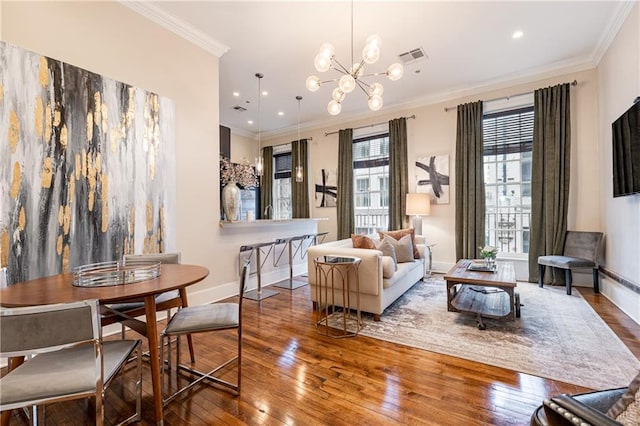 living area featuring a notable chandelier, ornamental molding, visible vents, and hardwood / wood-style floors
