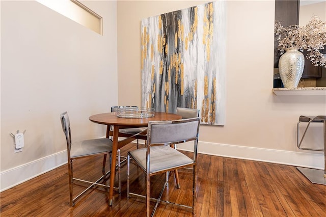 dining area featuring baseboards and hardwood / wood-style flooring