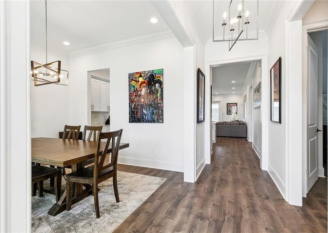 dining area with dark wood-style flooring, baseboards, an inviting chandelier, ornamental molding, and recessed lighting